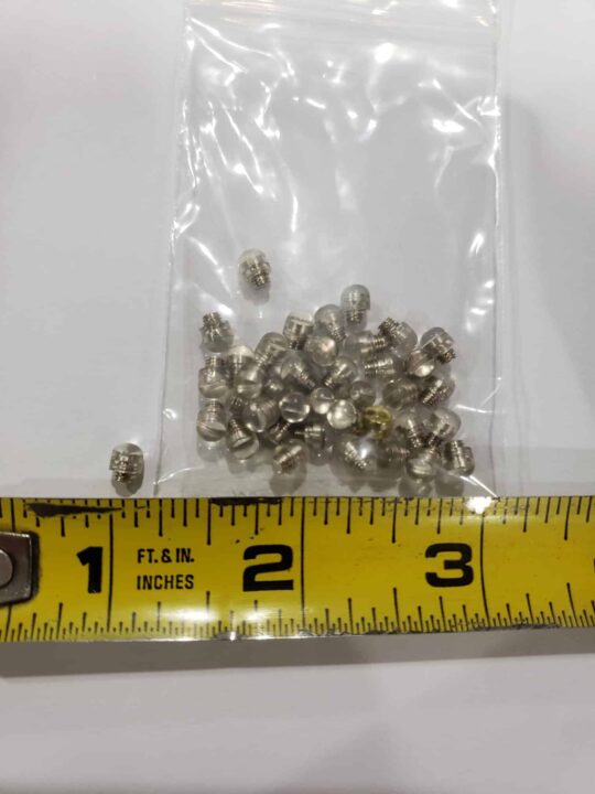 Bulk Rubber Bumpers are displayed in a small plastic bag with several metal parts, placed above a yellow measuring tape marked in inches.