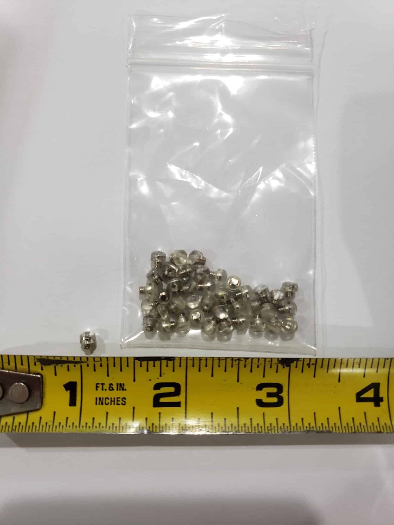 A small clear bag of silver crimp beads sits above a yellow tape measure, showing they're under a quarter inch—perfect for jewelry making or pairing with Bulk Rubber Bumpers in craft projects.