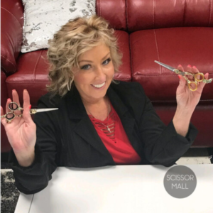 An organized collection of professional hair cutting shears laid out on a salon table
