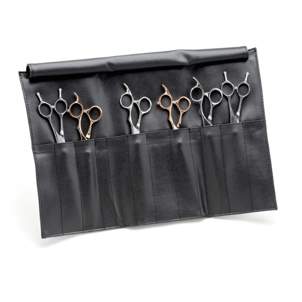 Assorted hairdressing shears including thinning and texturizing tools laid out on mat